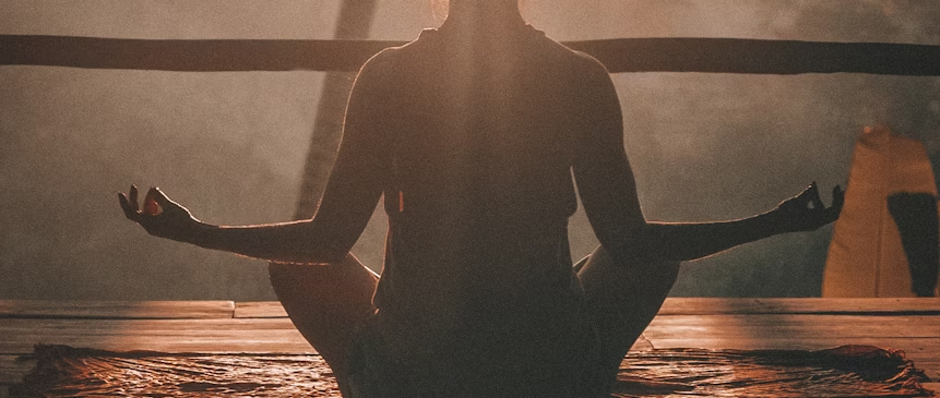 woman doing yoga meditation on brown parquet flooring